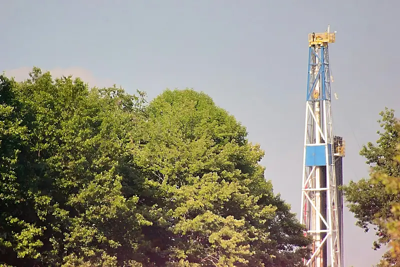 A borehole drilling rig set up among trees